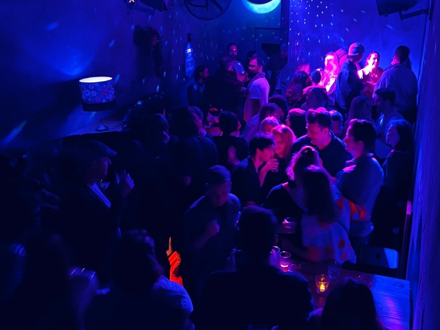 Guests in Sugar Glider’s main room under blue and purple lighting